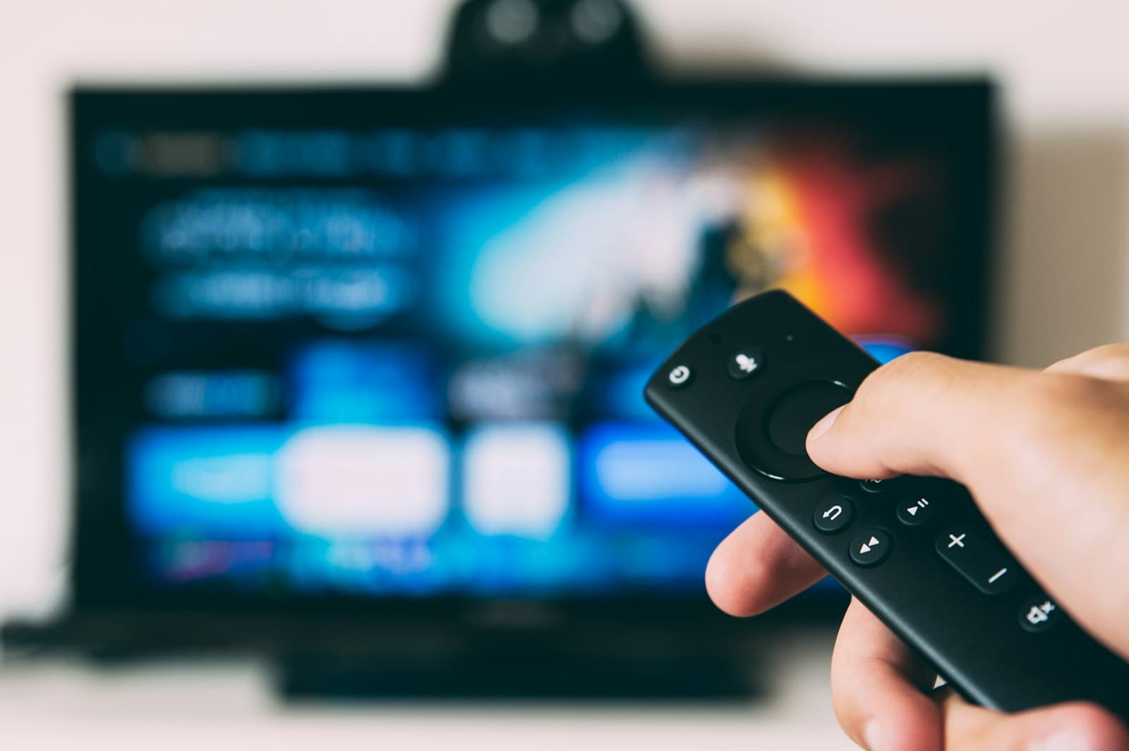 Person pointing a streaming remote at a TV