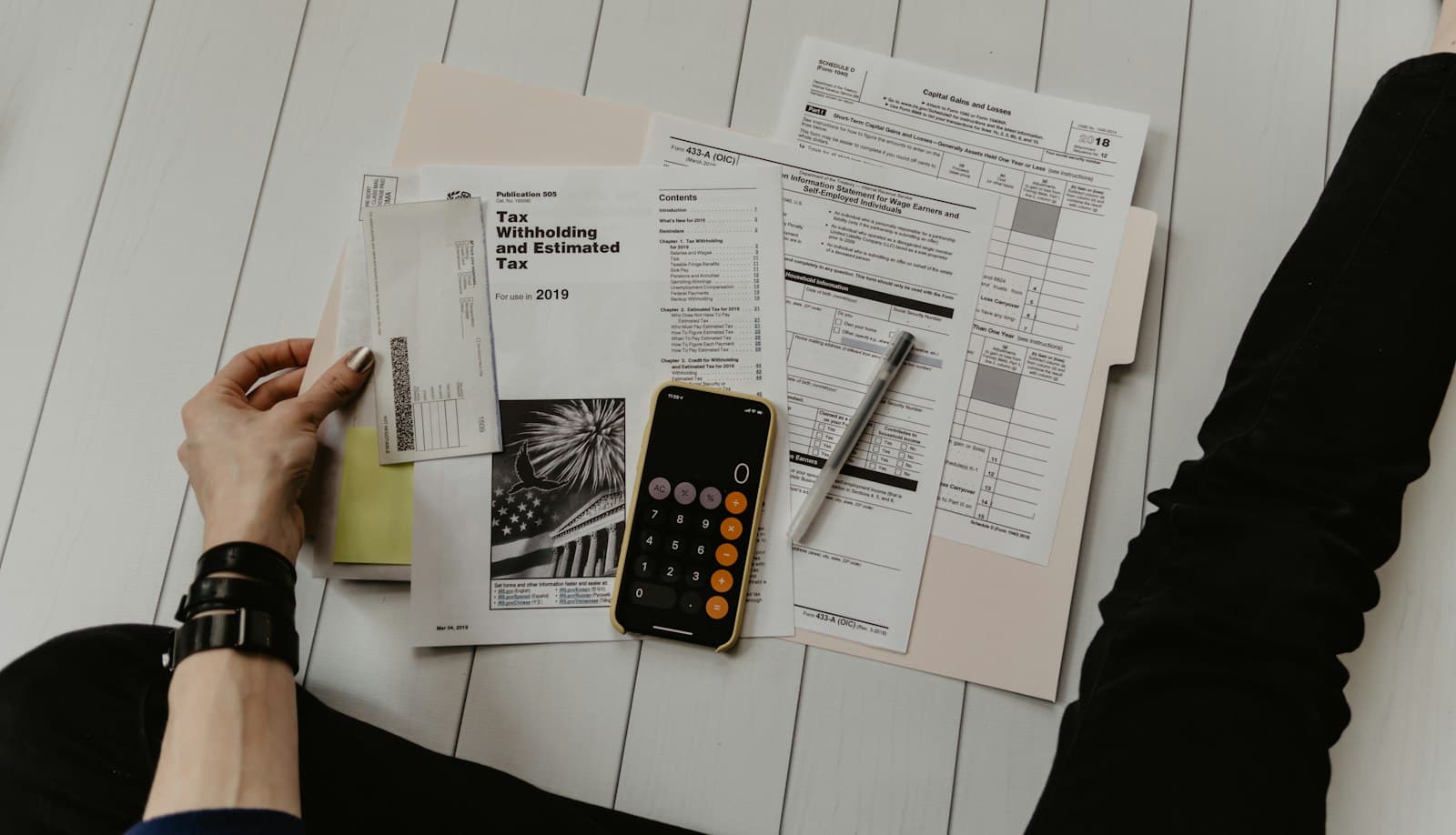 Calculator, pen and paperwork on a desk