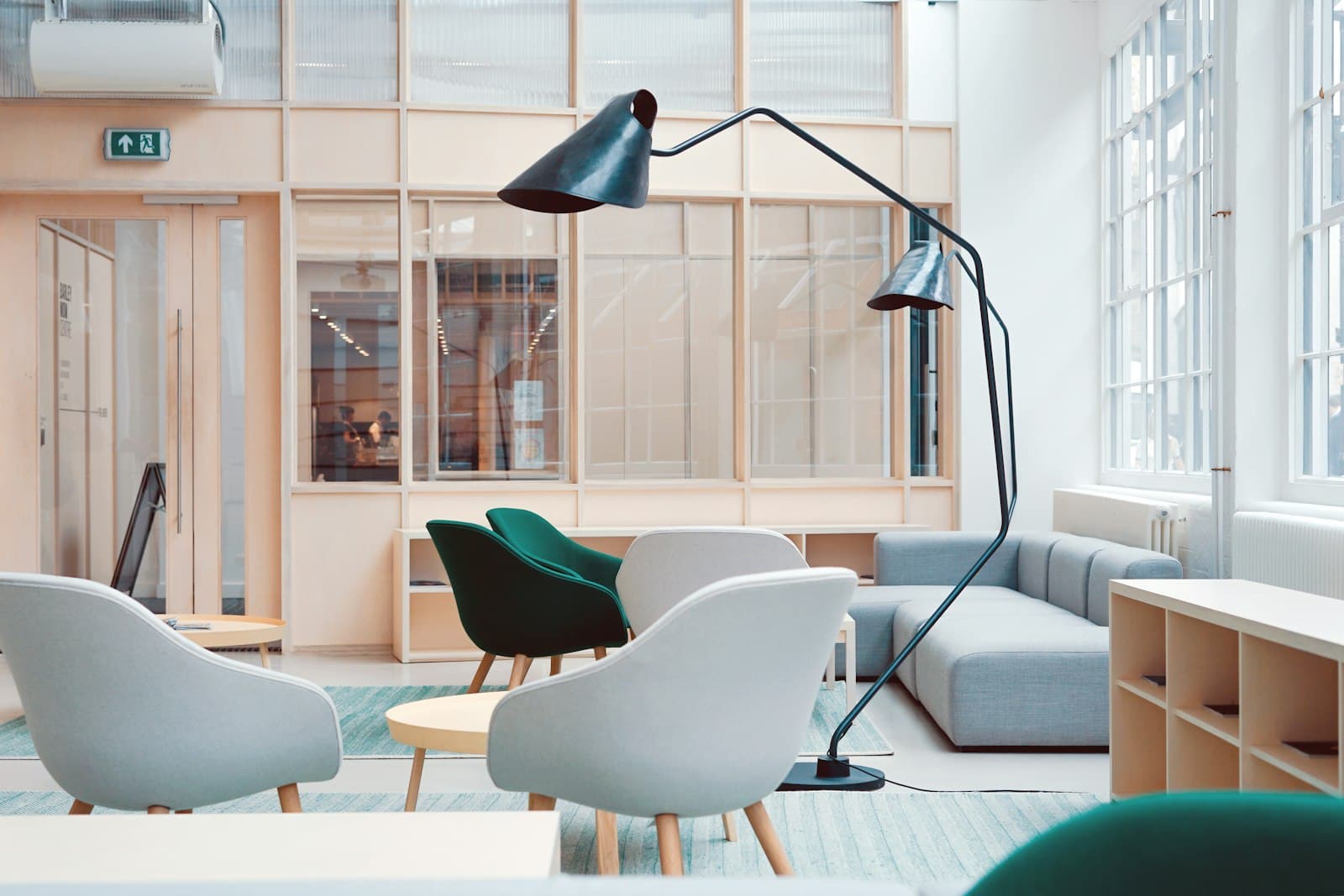 Bright open-plan lounge with armchairs and a floor lamp