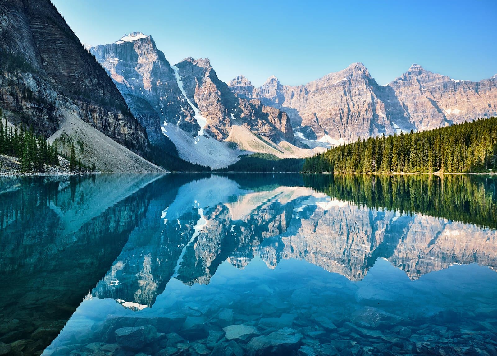Turquoise mountain lake surrounded by forest and rocky peaks