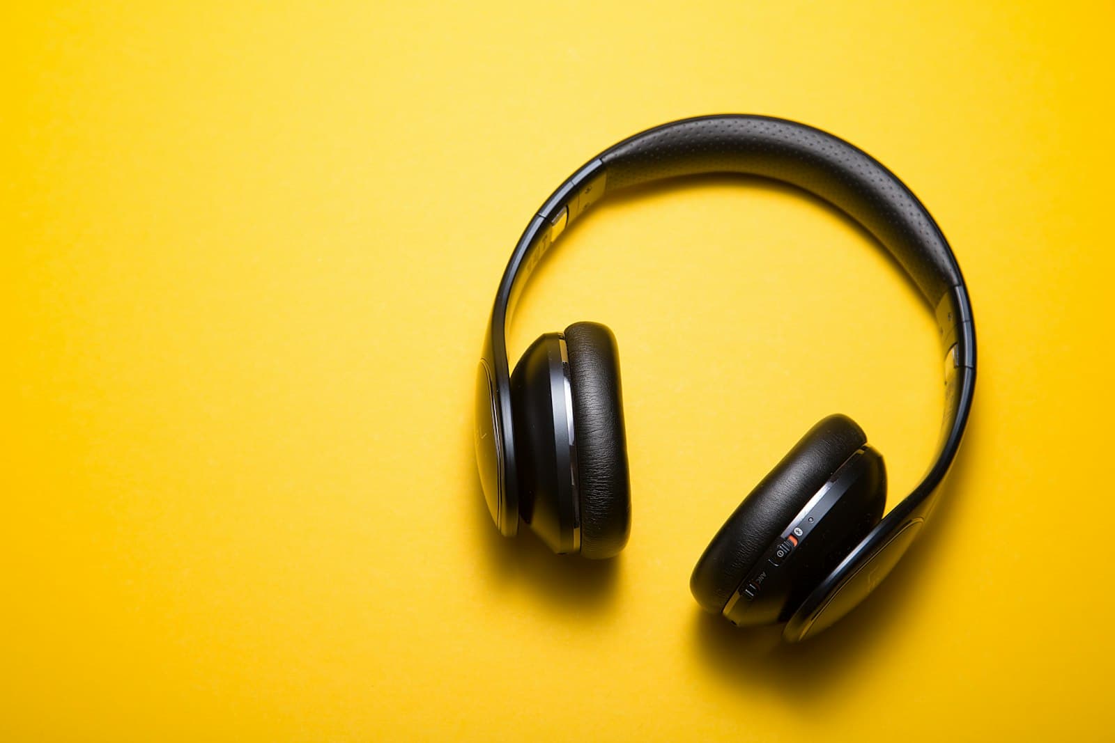 Over-ear headphones on a bright yellow background