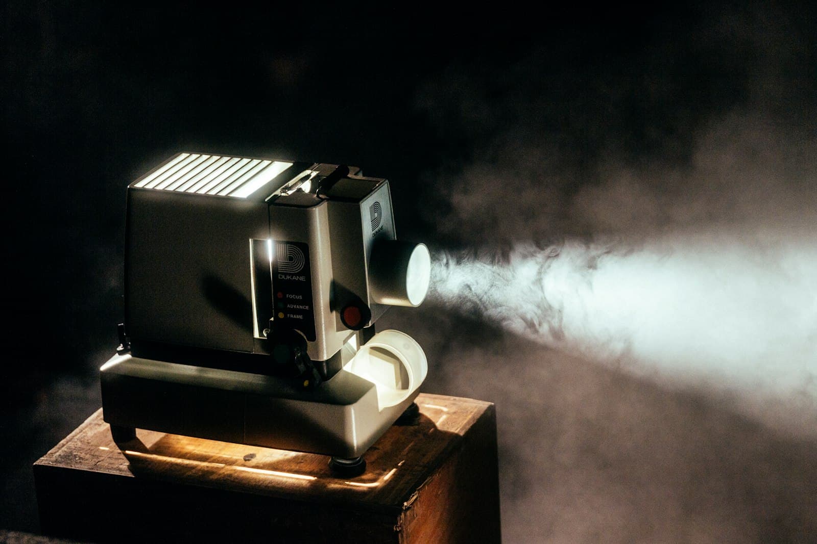 Film projector casting a beam of light in a dark room